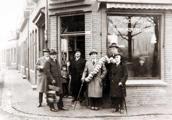 Bezoek van Anton Philips (2e van links) aan de kruidenierszaak van de Coöp. ETOS aan de De Jonghlaan, hoek Frederiklaan.