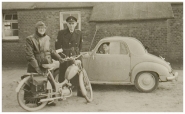 Woonwagenkamp Eindhoven. Links agent met motor (een Harley Davidson M50 of is het een Magneet?) rechts in de auto maatschappelijk werkster Jeanne van Gotum. Tussen hen in agent Jan Pijnenborgh. – collectie RHCe